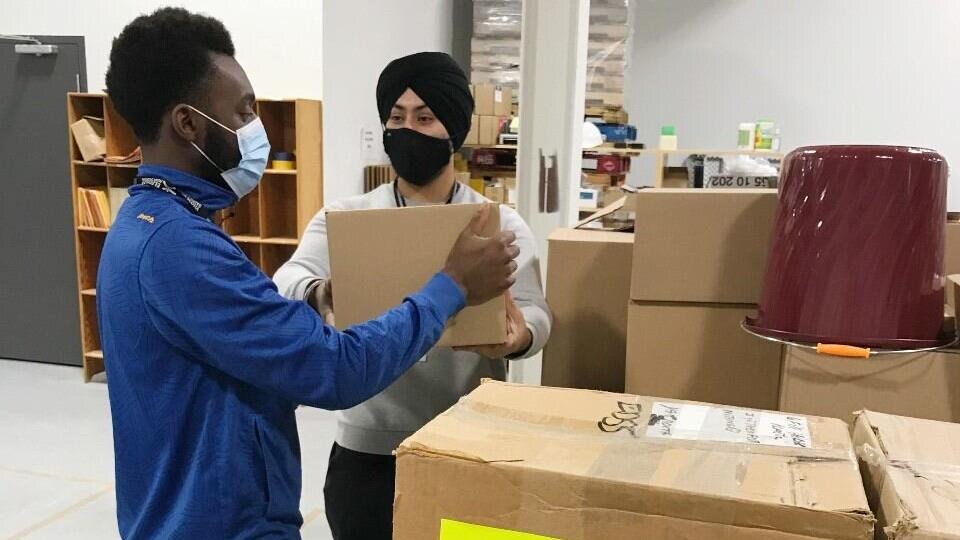 Des travailleurs d'Élections Nouvelle-Écosse dans un entrepôt à Dartmouth.