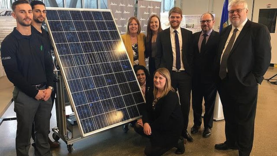 La ministre de l'Énergie, Margaret McCuaig Boyd avec des étudiants devant un panneau solaire