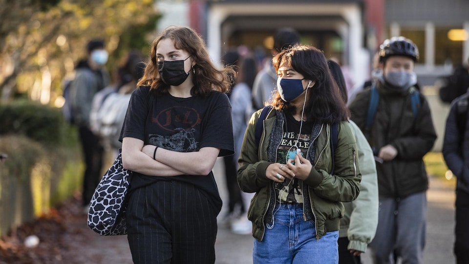 Des étudiants marchent à la sortie des classes et portent un masque contre la COVID-19.