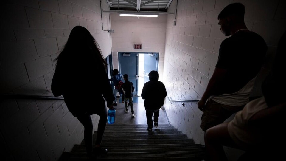 Des élèves marchent dans un escalier à l'école secondaire.