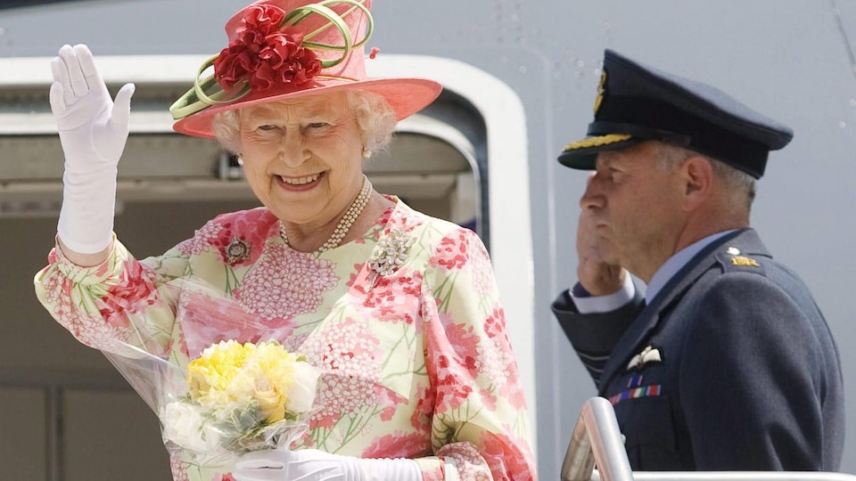 La reine Élisabeth salue de la main en montant dans son avion en direction de New York.