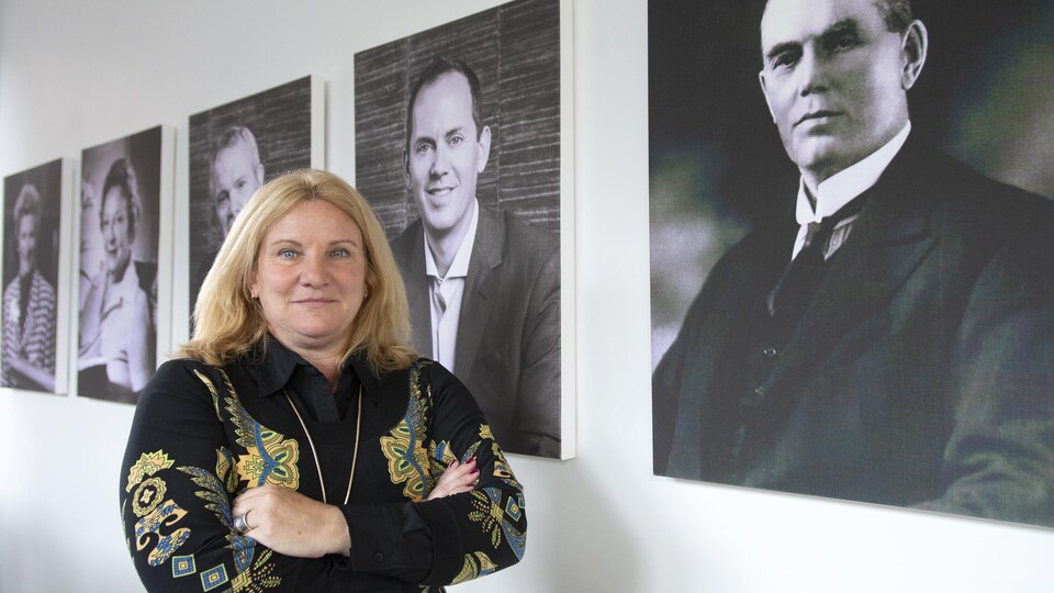 Elisabeth Ann Laett devant des portraits de la famille Holt, aux bureaux de l'entreprise The Holt Xchange.