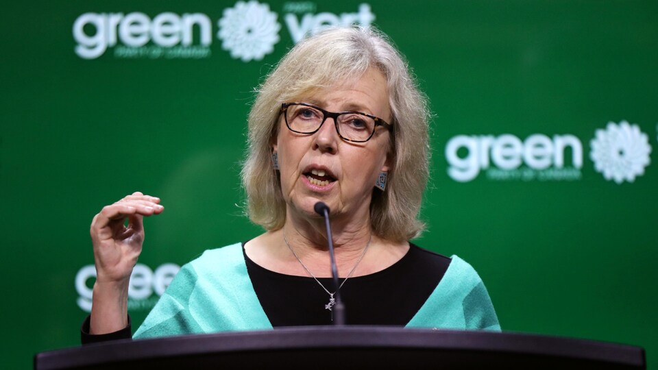 Elizabeth May parle dans un micro.