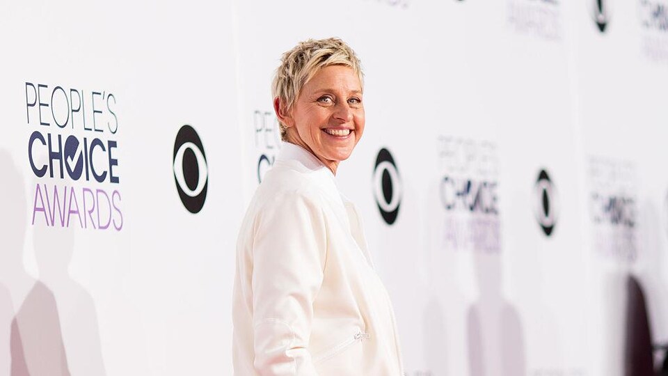 Ellen DeGeneres pose vêtue de blanc. 