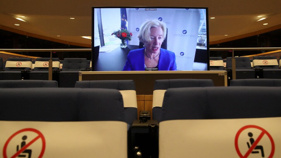 Emer Cooke, sur un téléviseur installé au milieu d'une salle vide.