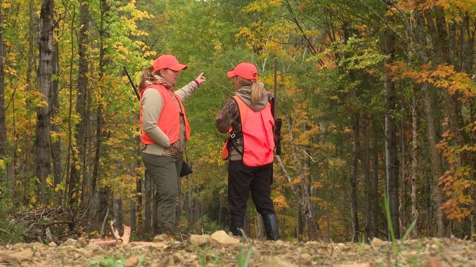 Deux chasseuses dans les bois, vêtues d'habits de chasse.