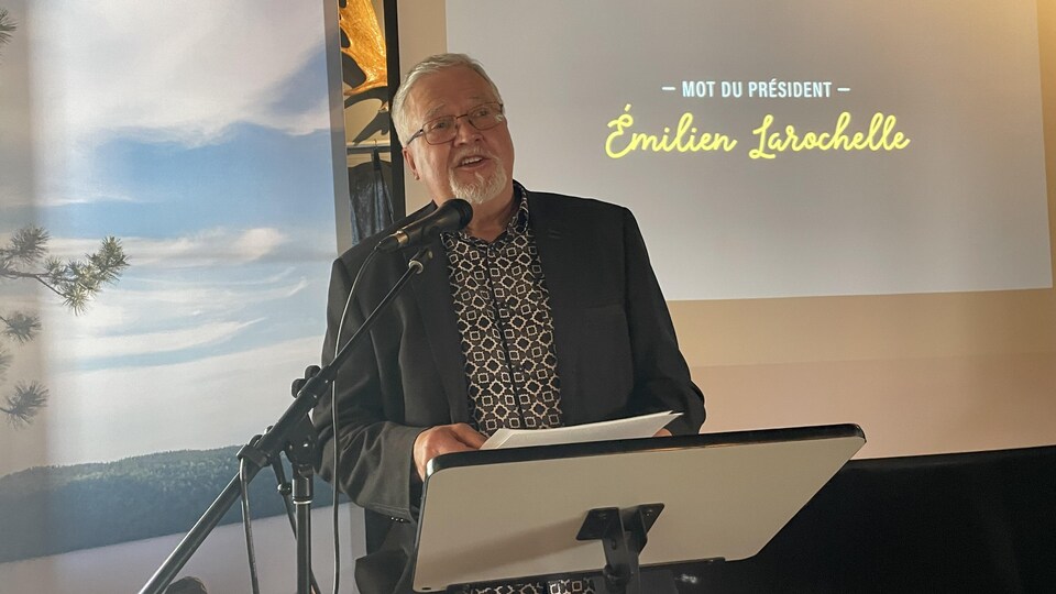 Émilien Larochelle speaks behind a lectern.