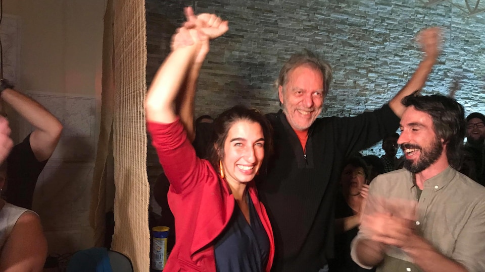 Émilise Lessard-Therrien lève les mains en l'air en compagnie de Guy Leclerc, ancien candidat de Québec solidaire.