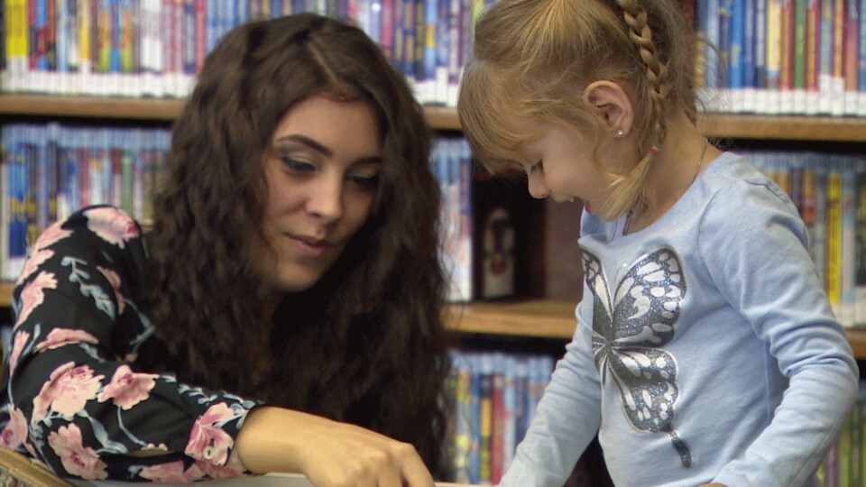Courtney Castonguay joue avec sa fille sur une table à la bibliothèque.