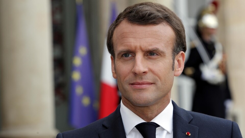 Le président français Emmanuel Macron pose devant le palais de l'Elysée.