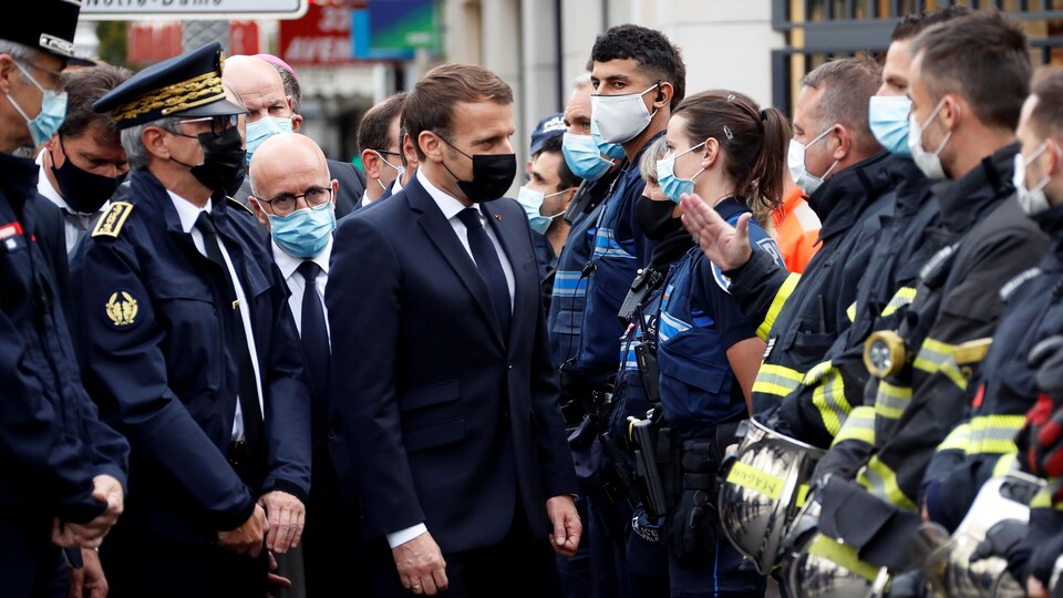 Le président Macron discute avec des policiers.