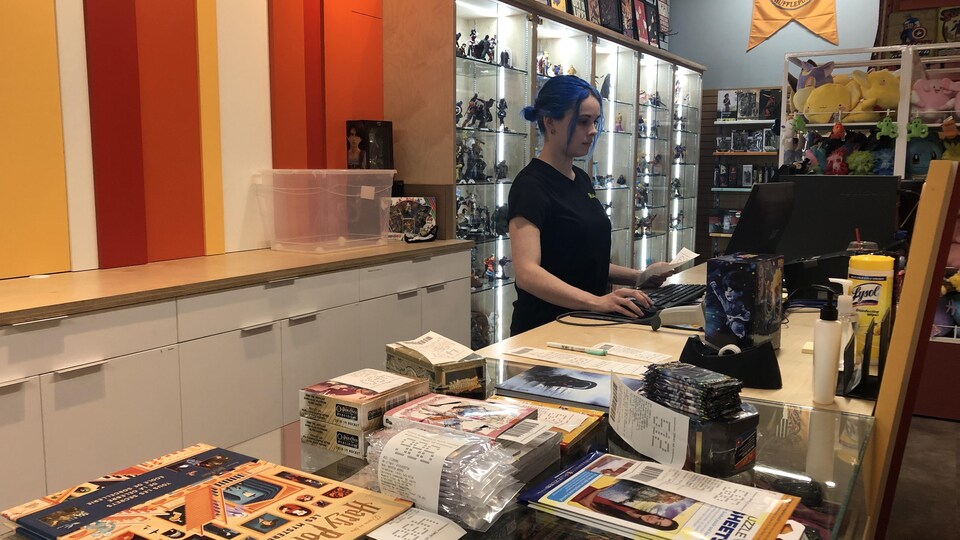 Une femme regarde une ordinateur à la caisse d'un magasin .