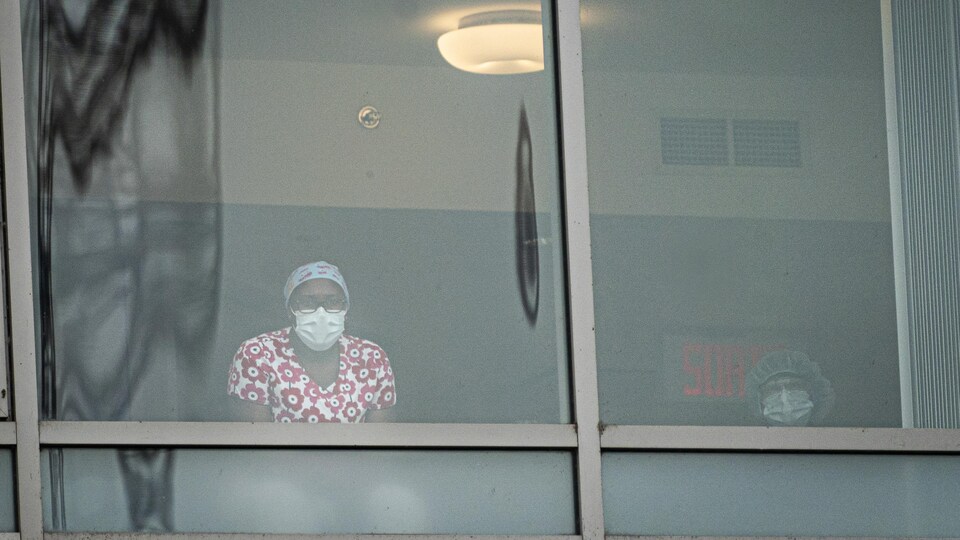 Des employées du CHSLD Marcelle-Ferron derrière une vitre