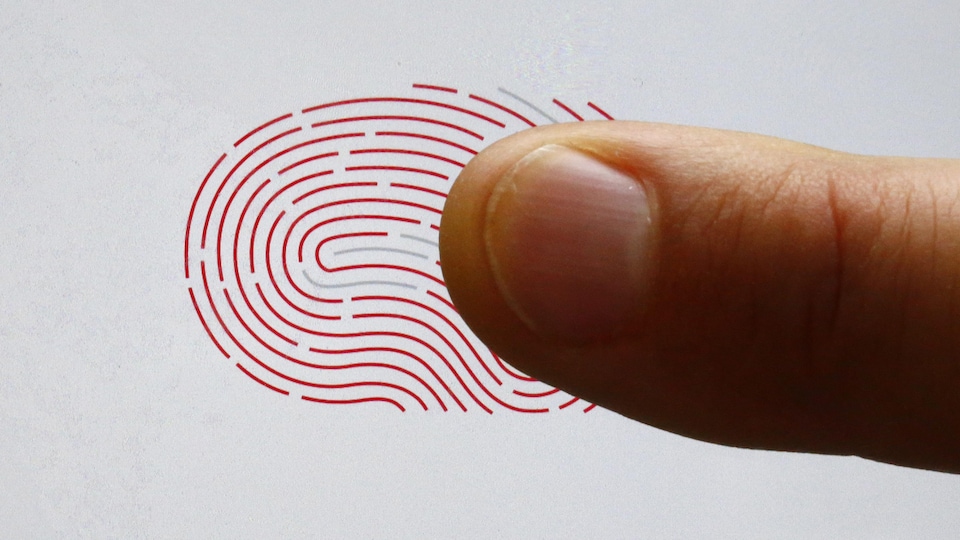 Une personne utilise un scanner biométrique avec son doigt.