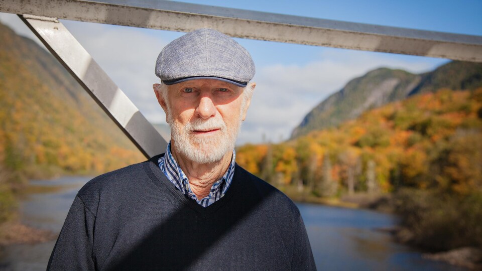 Coiffé d’un béret, Jean Bédard se tient devant le parc de la Jacques-Cartier.