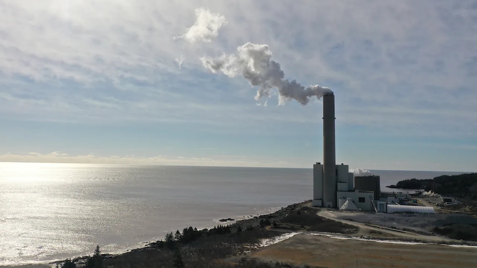 La centrale surmontée d'une haute cheminée est à deux pas de la mer.