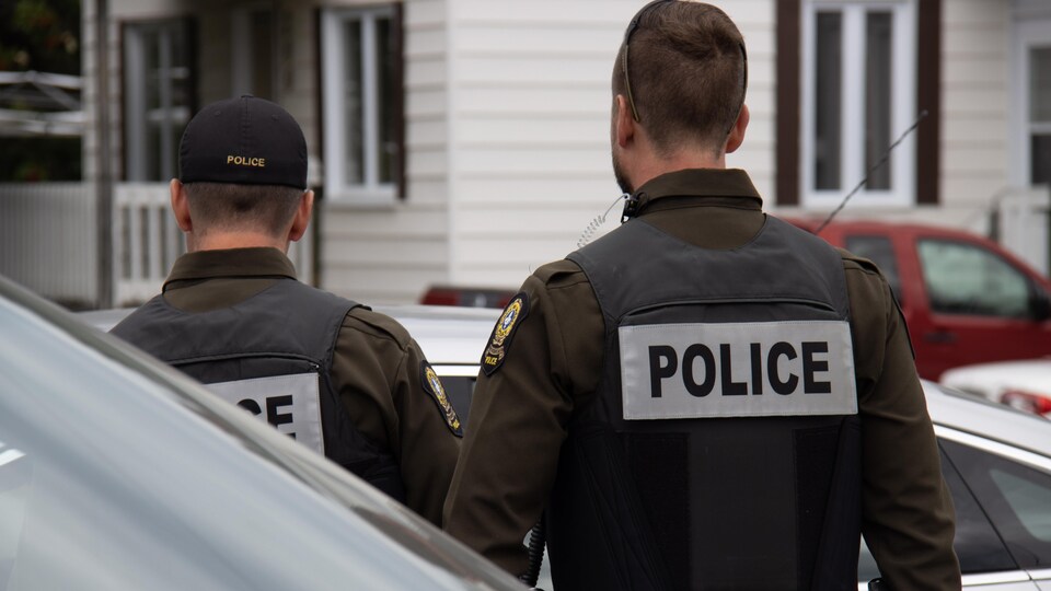 Deux policiers de dos lors de l'intervention de Sainte-Paule.