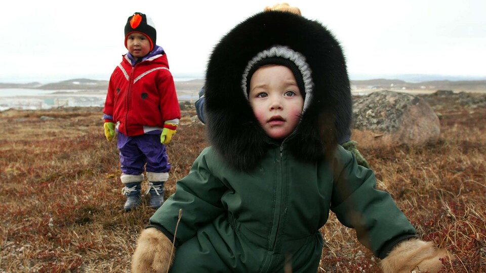 Deux enfants dans un champ, à Iqaliut.