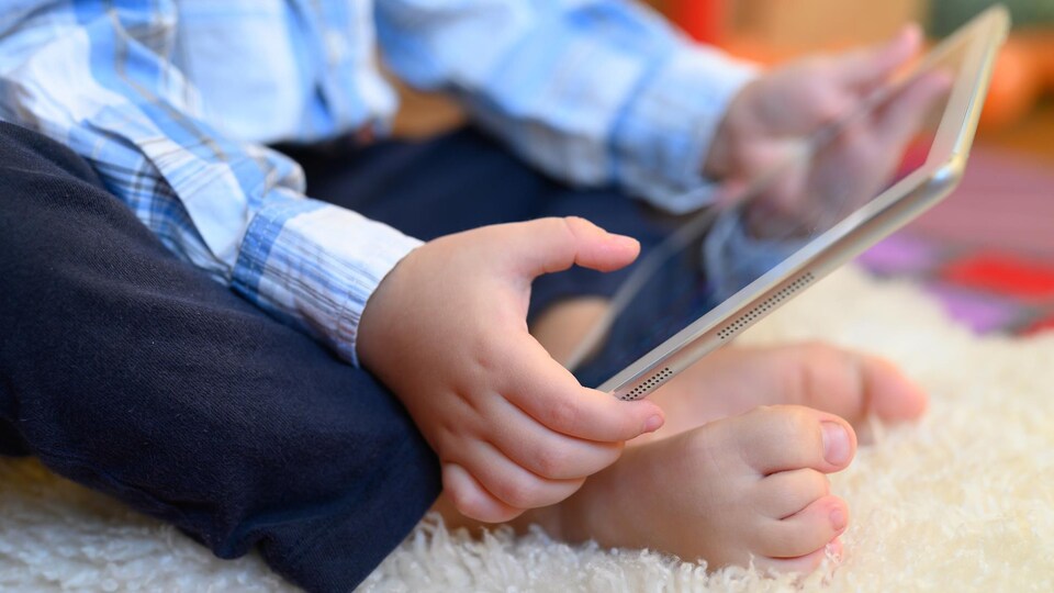 Un enfant tient une tablette dans ses mains