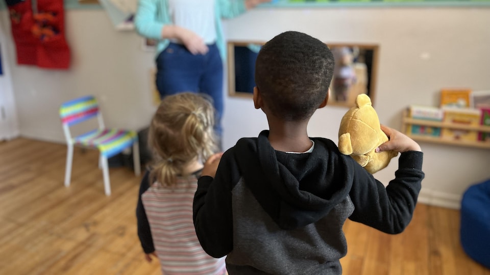 Two children and their tutor at the drop-in center.