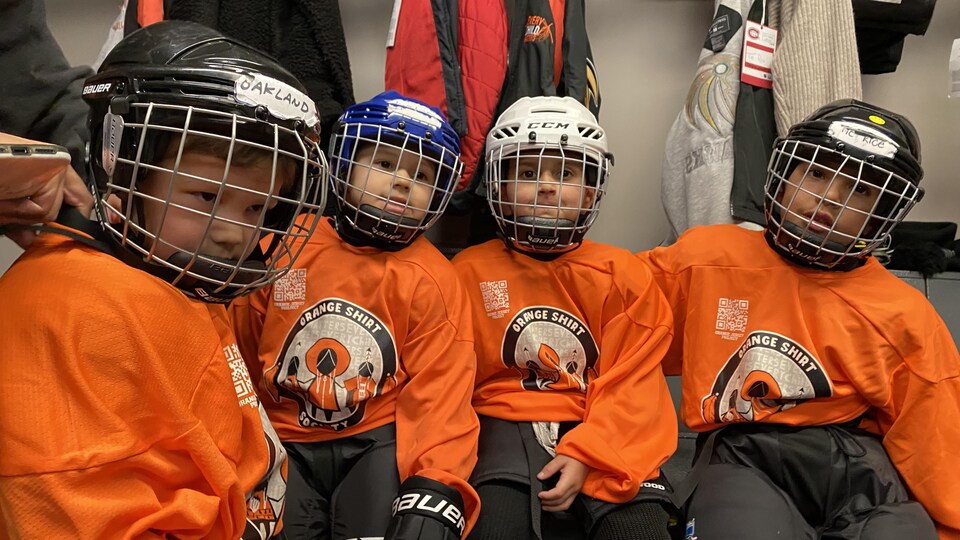 De jeunes enfants en tenue de hockey.