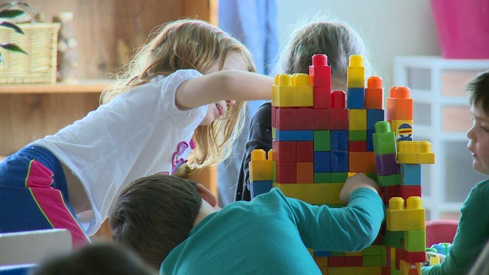 Des enfants jouent avec des blocs colorés.