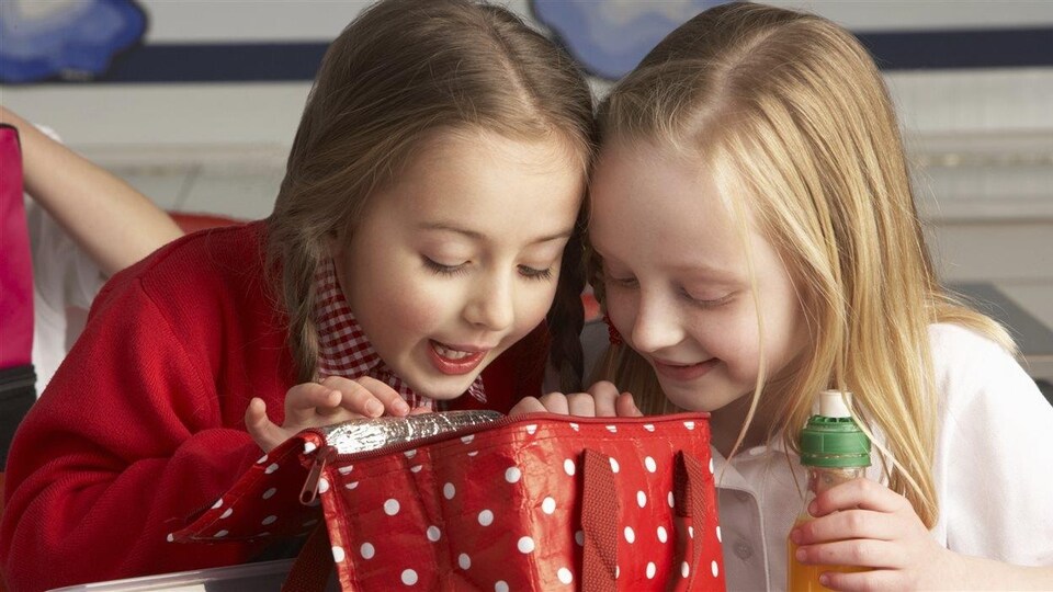 Des enfants regardent l'intérieur d'une boîte à lunch