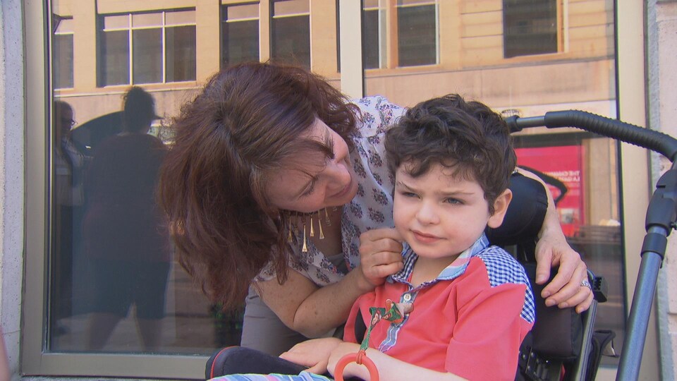 Une mère prend soin de son fils dans une poussette.