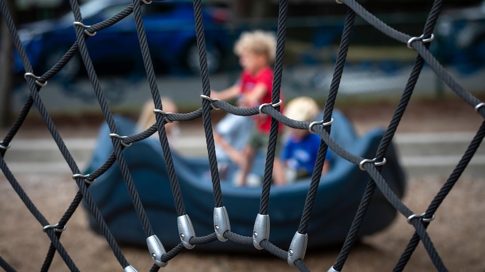 Trois enfants jouent au parc.