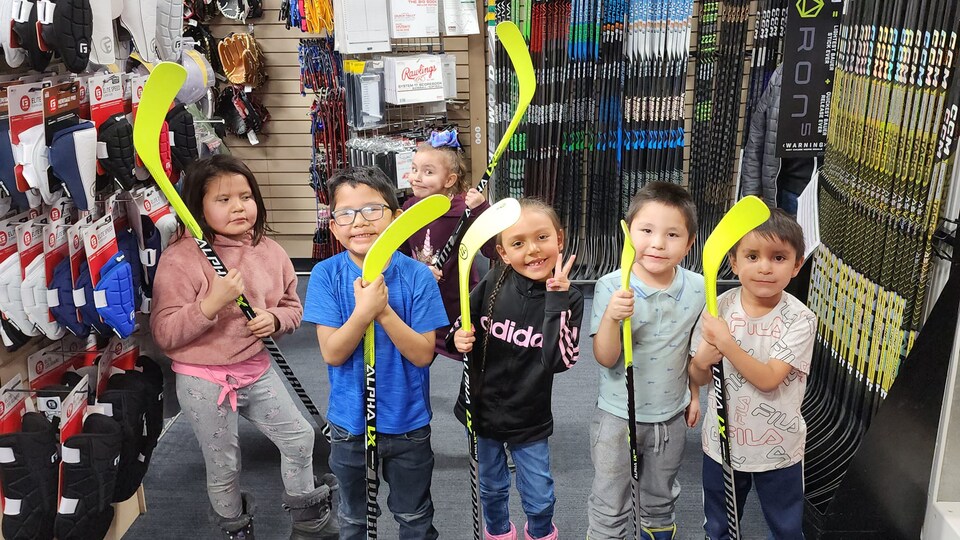 Des enfants de la Première Nation George Gordon avec des bâtons de hockey.
