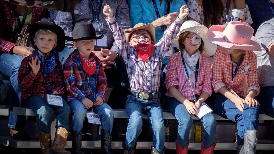 Un groupe d'enfants habillés en cow-boy regardent le défilé.