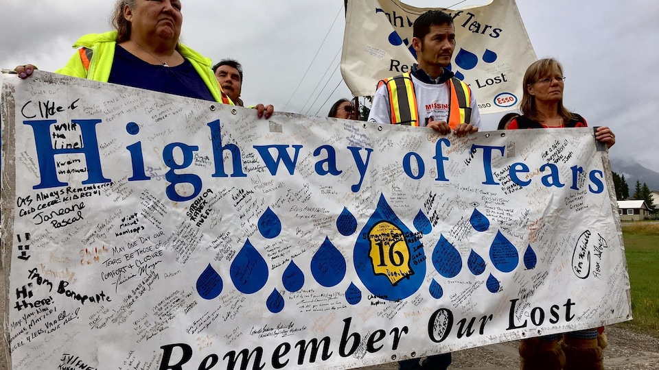 Des membres de la famille des victimes tiennent un étendard le long de la Route des larmes le 25 septembre 2017