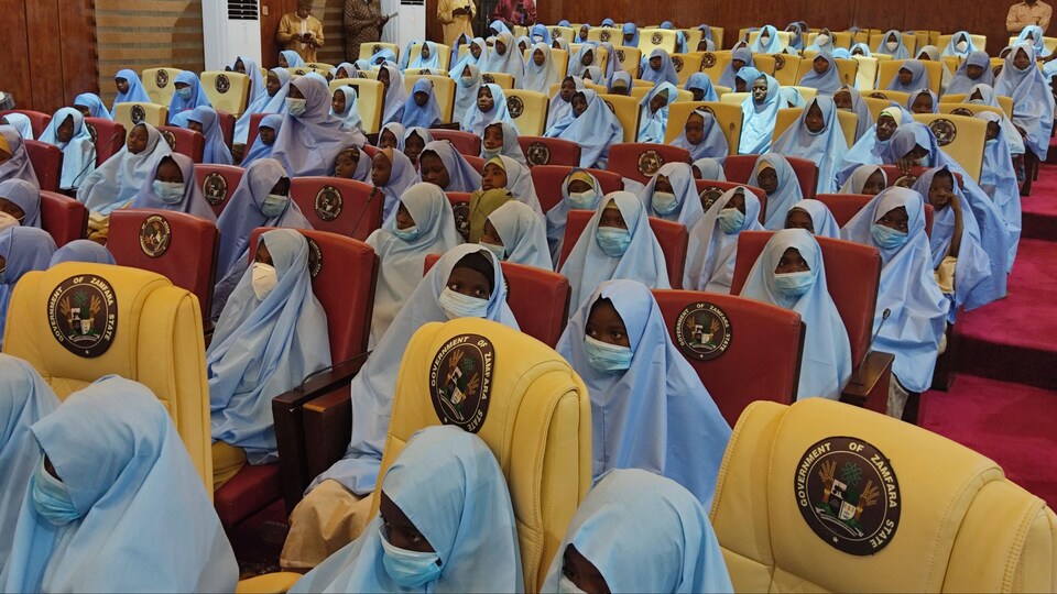 Des dizaines de jeunes filles en hidjab avec un masque contre la COVID-19 assises.