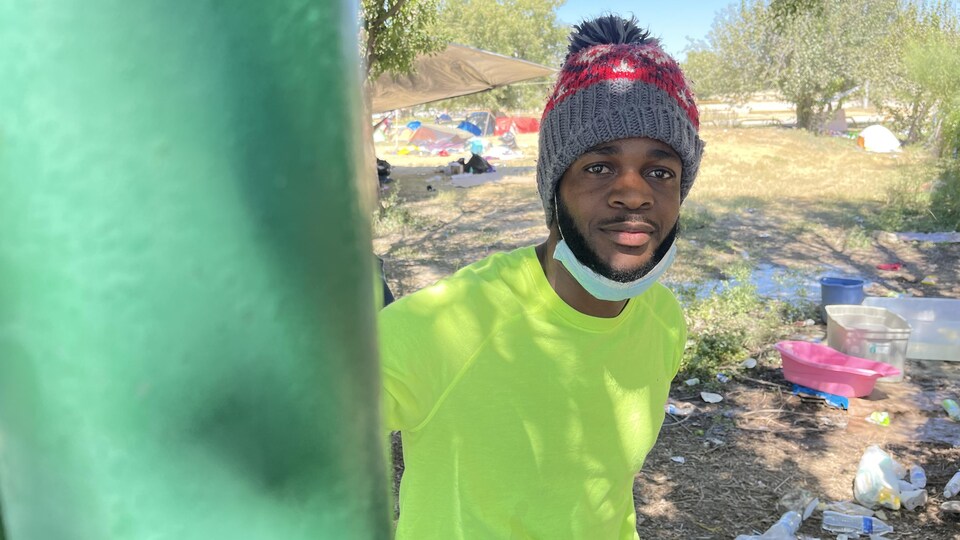 Un homme avec une tuque sur la tête entouré de déchets.