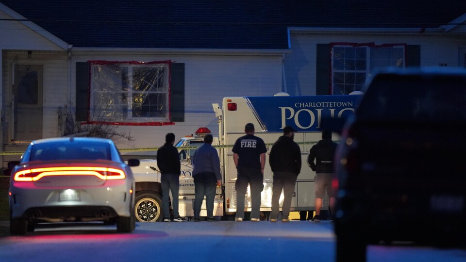 Des gens près d'un camion de police.