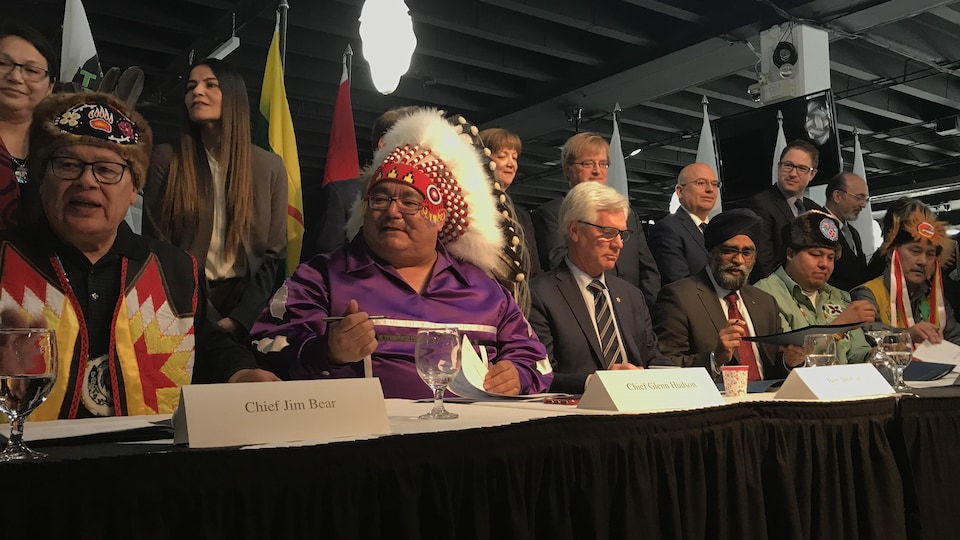 Le ministre de la Défense, Harjit Sajjan, et le ministre des Ressources naturelles, Jim Carr, ainsi qu'une dizaine de chefs autochtones présents lors de l'annonce.