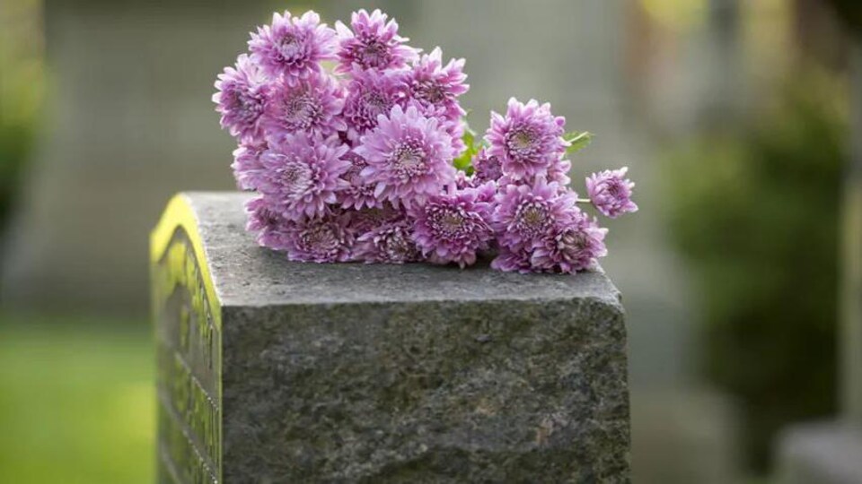 Des fleurs sur une pierre tombale.