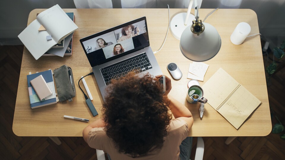 Une femme à sa table de travail devant son ordinateur