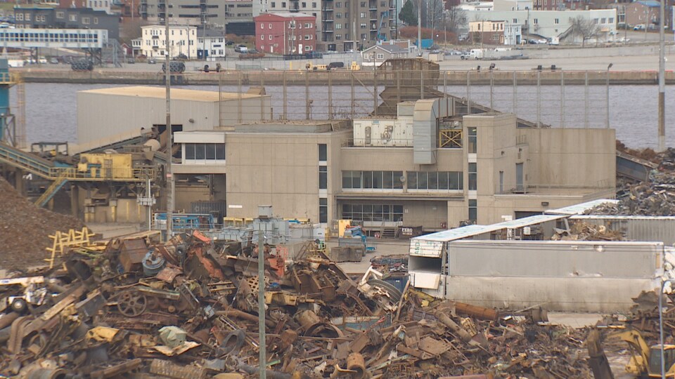Des amas de pièces métalliques entourent l'usine.