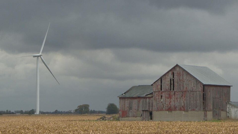 L'éolienne est proche d'une grange.