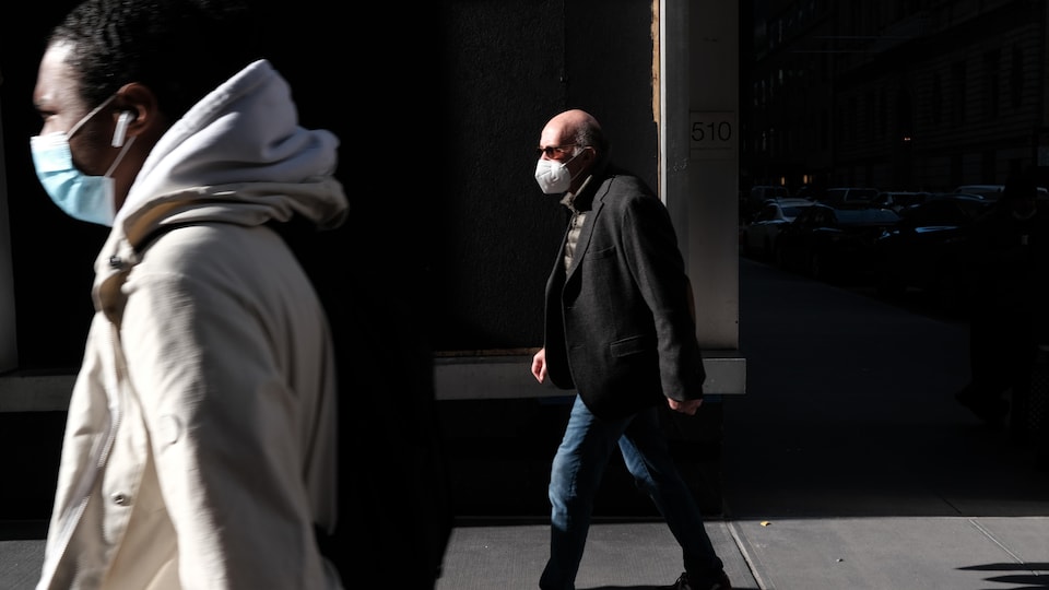 Des piétons portant un masque à New York.