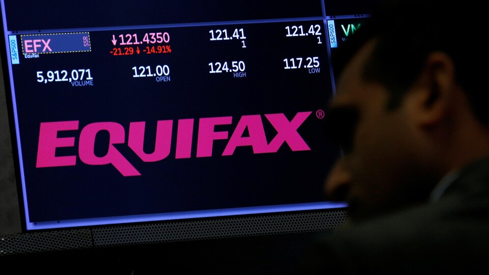 Le visage d'un homme est vu de profil, devant le logo d'Equifax qui apparaît sur un écran à la Bourse de New York.