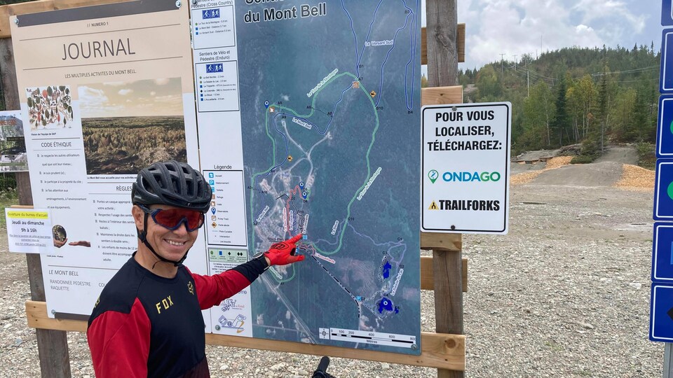 Éric Allaire pointe un sentier sur une carte du Mont Bell à Senneterre.