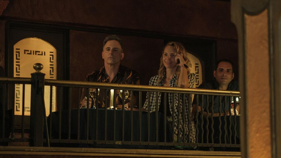 L'homme et la femme sont assis sur le balcon et semblent regarder de loin un spectacle. 