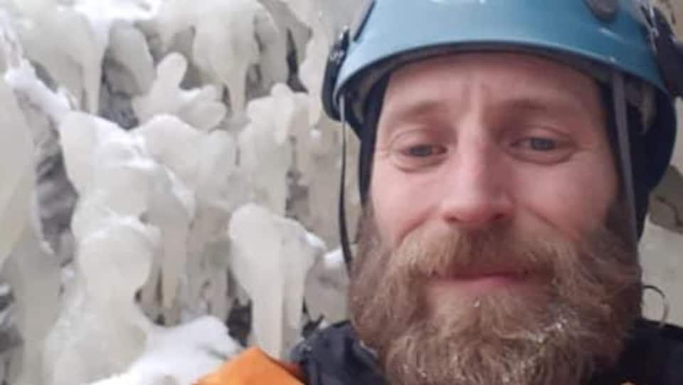 Un homme prend un égoportrait dans son habit de spéléologie, devant la glace.