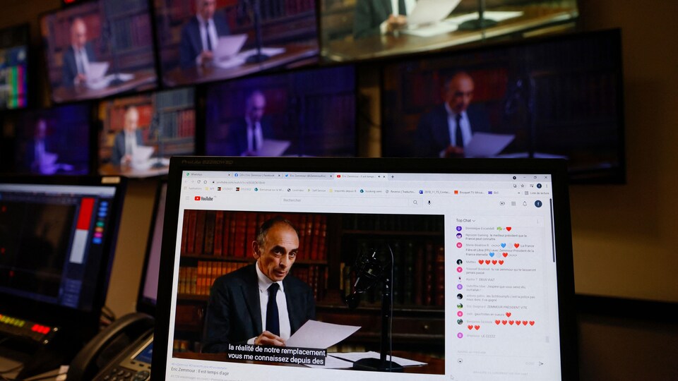 Un mur d'écrans sur lesquels apparaît le candidat en train de lire un discours.