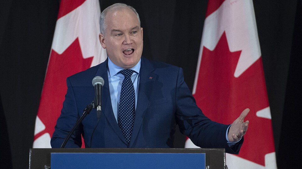 Erin O'Toole, derrière un podium, s'adresse à des partisans.