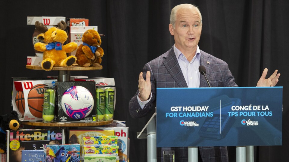 Erin O'Toole debout à côté d'un tas de jouets.