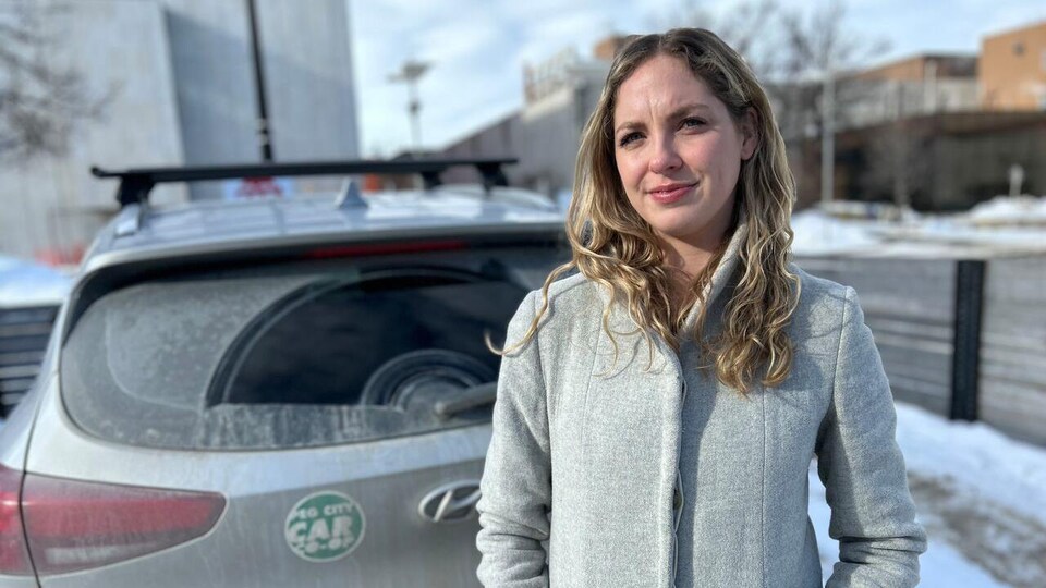 Erin Reidiger devant une voiture de la Peg City Car Co-op
