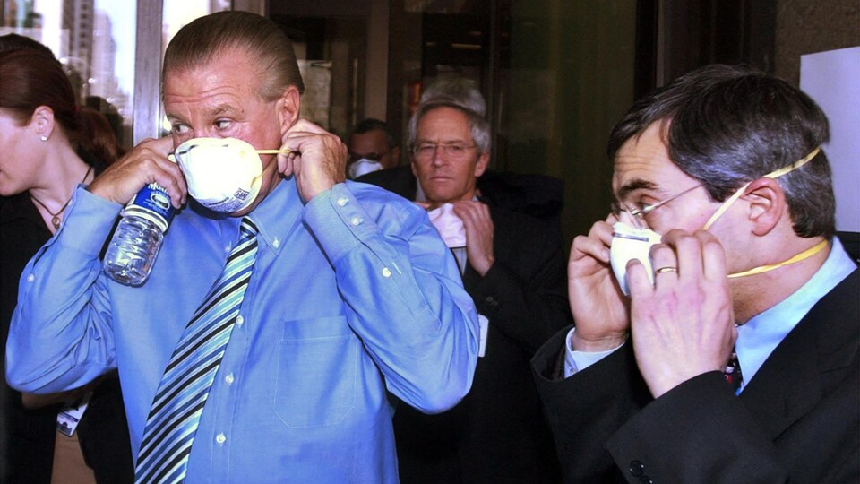 Deux hommes mettent un masque.